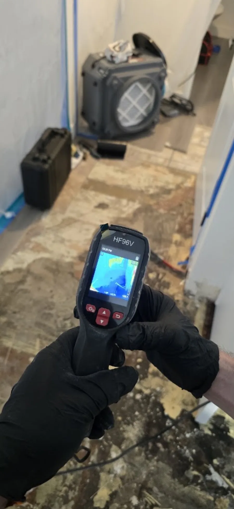 Technician using a thermal imaging device in an affected area
